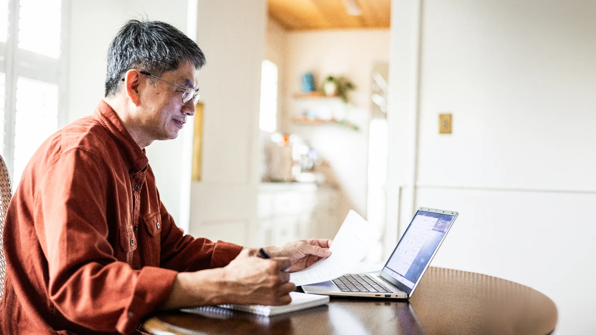 Senior man working on a laptop in his home