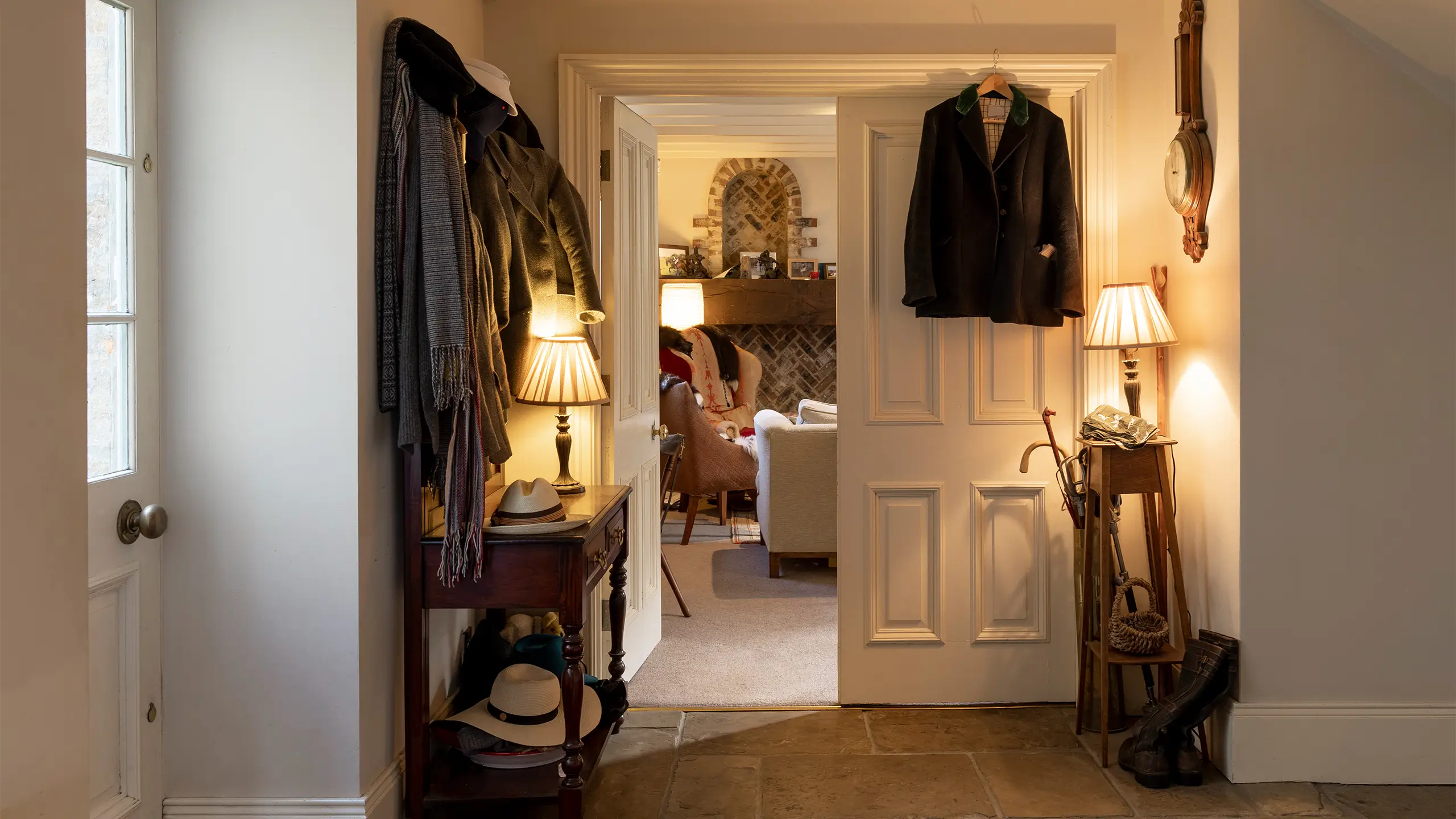 An entrance hall in a cosy country home in Newcastle Upon Tyne, England. All the lights are on, making the ambience warm and welcoming.