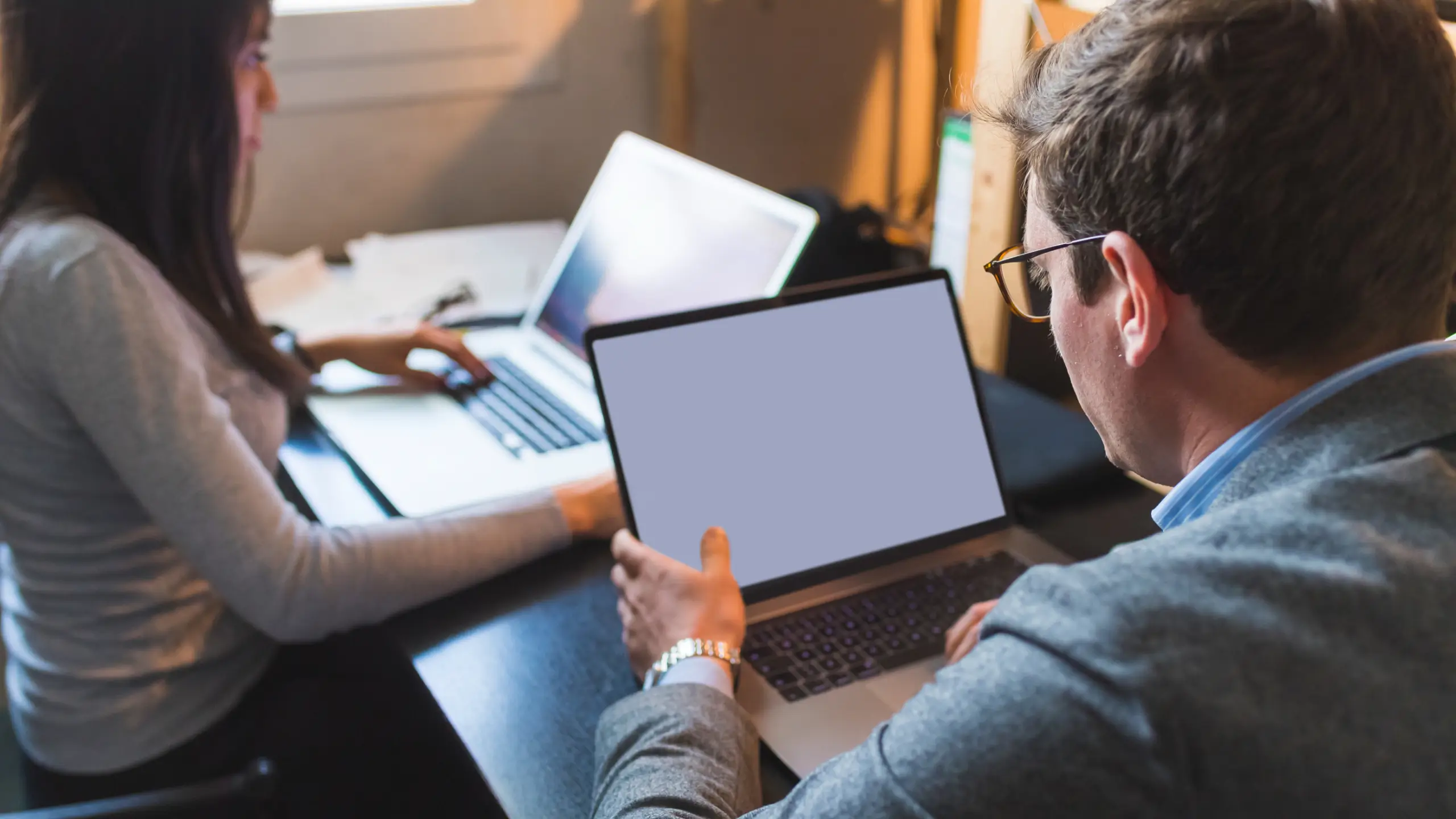 Business man and woman using laptops
