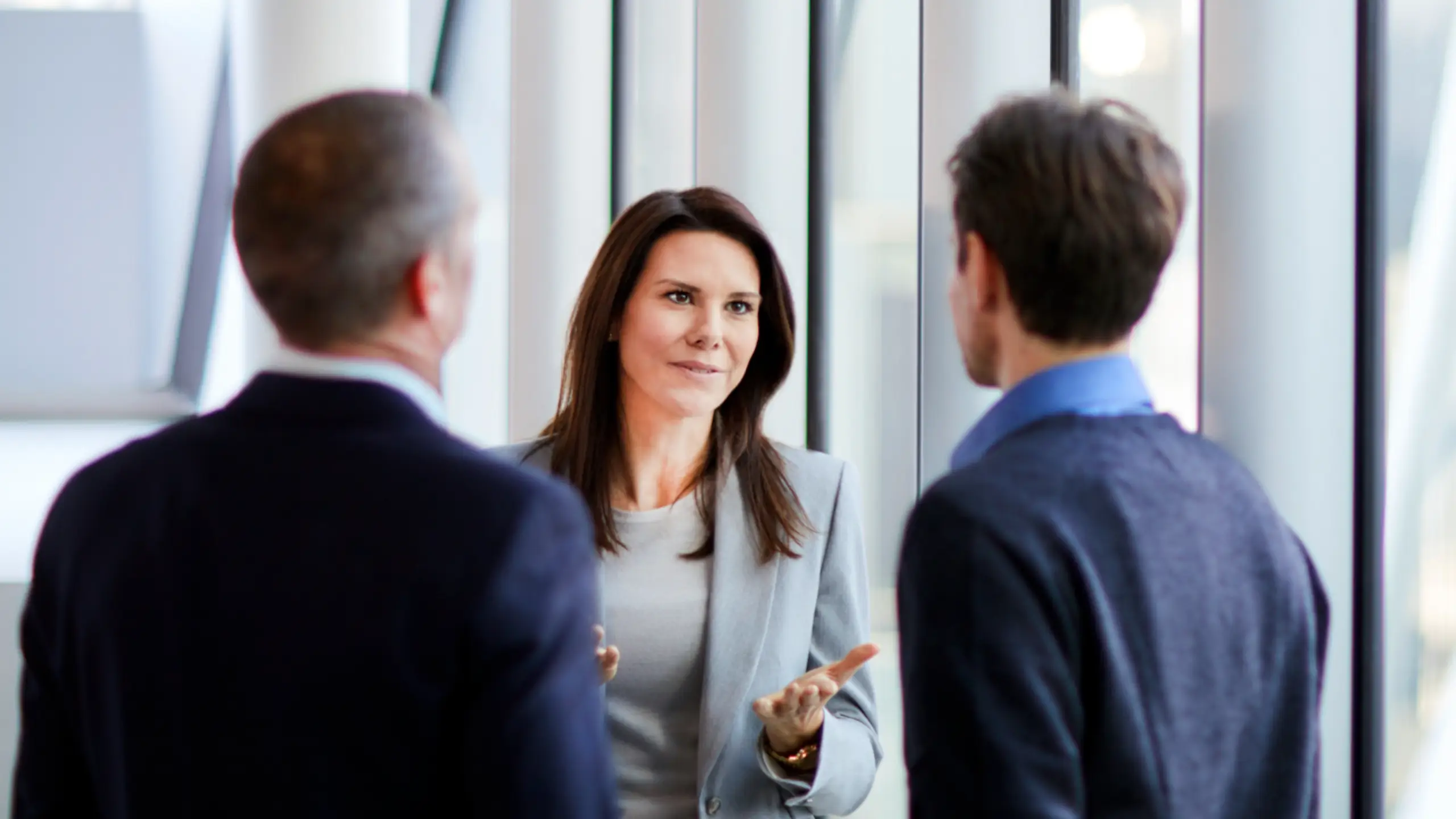 Businesswoman talking to businessmen at office window