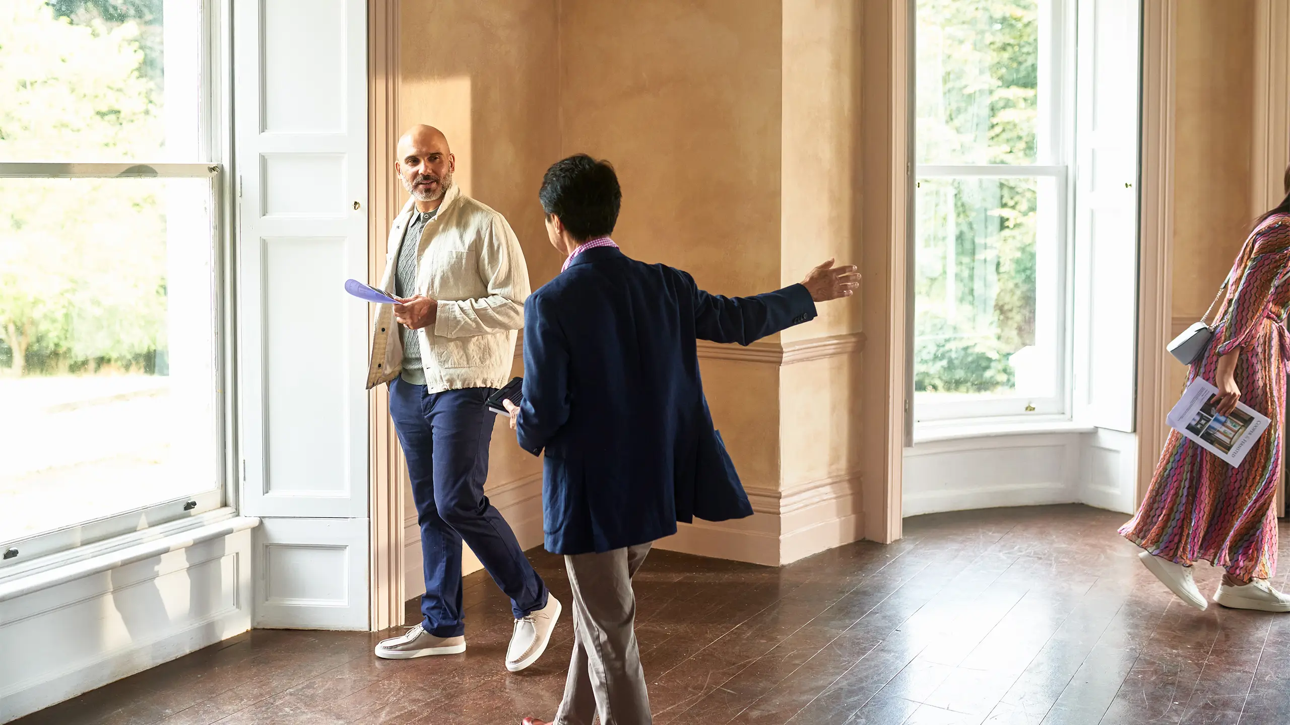 Senior real estate agent showing couple around potential new house pointing out features in spacious empty room, real estate, potential, new life