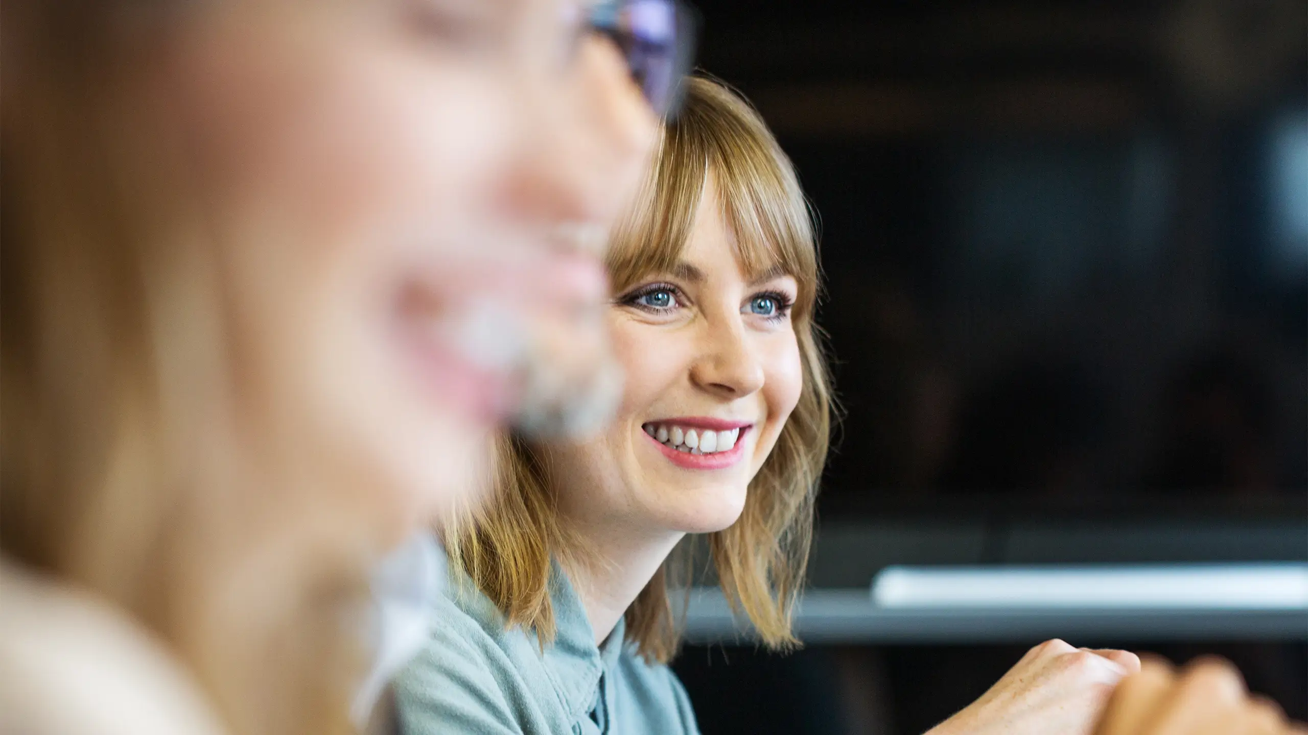 Young businesswoman sitting in meeting and listening to conversation. Female professional listening to colleague in meeting.